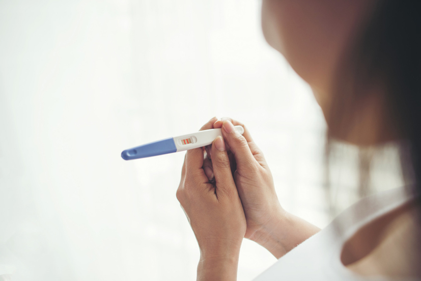 woman holding pregnancy test<br />
